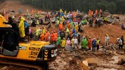 People watch as search operations are carried out after landslides hit Mundakkai village in Wayanad district in the southern state of Kerala