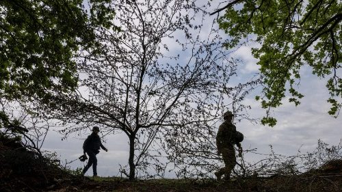 Servicemen of Ukraine's 57th brigade walk near an artillery position at the outskirts of Kupiansk